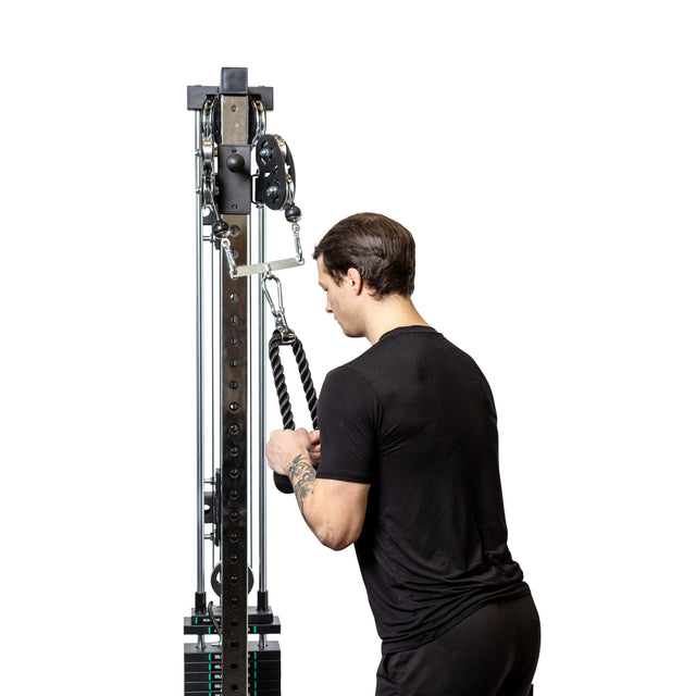 A man in a black t-shirt uses the Bells of Steel 2 to 1 Cable Attachment Adapter for exercise, viewed from the back against a white background.