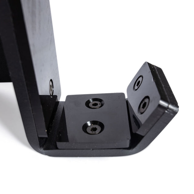 Close-up of a black metal Standard J-Cups by Bells of Steel, featuring three visible screw holes, attached to a black surface for UHMW protection in power racks, photographed against a white background.