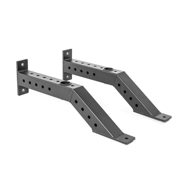 Two black metal Front Foot Stabilizers by Bells of Steel, each with multiple circular holes, angled design, and mounting plates at both ends, are placed parallel on a white background.