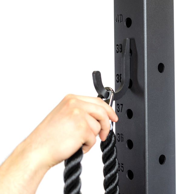 A hand clips a thick black rope to the Bells of Steel Utility Hook on a numbered gym rack, offering an efficient storage solution; numbers 36 to 40 are visible on the rack’s upright post.