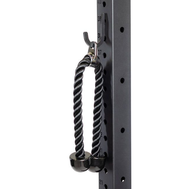 A Bells of Steel Utility Hook holds a black tricep rope with rubber ends on a metal rack with numbered holes—a smart gym storage solution.