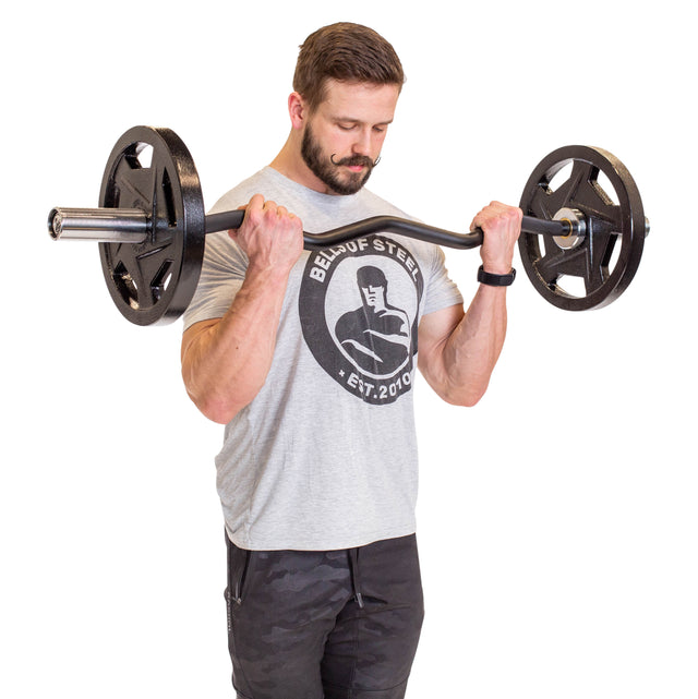 A bearded man in a light gray graphic tee and black pants performs a bicep curl with the Bells of Steel EZ Curl Bar (45"), standing against a white background.