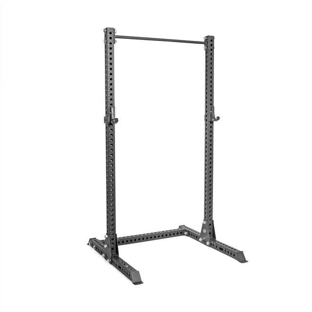 The Bells of Steel Manticore Squat Stand Builder features black 3"x3" steel uprights with 1" holes, a pull-up bar, and a wide base. Photographed empty on a white background, it's ideal for any home gym.