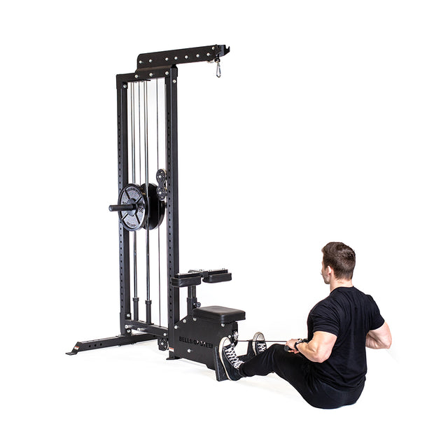 A man in black workout wear uses the Bells of Steel Lat Pulldown Low Row Machine, gripping the handle and pulling it to his torso, performing a cable exercise against a white, uncluttered background.