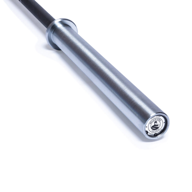 A close-up of the Bells of Steel Powerlifting Bar shows its silver textured grip and black shaft on a white background. This best budget power bar meets IPF specs, making it ideal for serious strength training.