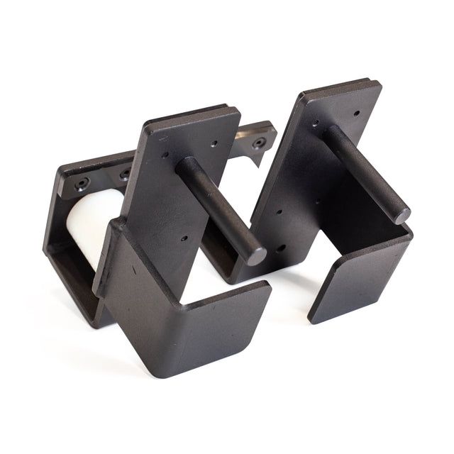 Bells of Steel Roller J-Cups are black metal wall-mounted brackets with cylindrical rods, providing secure support and barbell protection similar to those used in bench press setups.