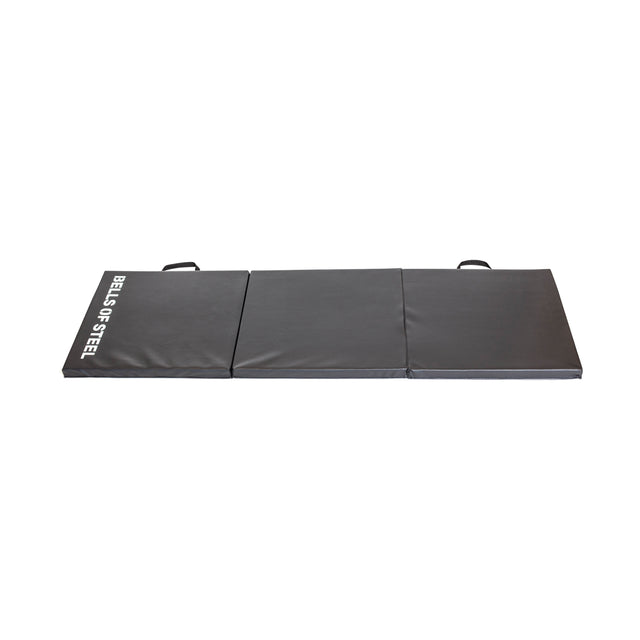A gray, foldable exercise mat ideal for the Wildman Turkish Get Up Kettlebell Bundle by Bells of Steel. It’s sectioned into three parts, each with a handle for easy carrying and "Bells of Steel" text in white on the side, photographed on a pristine white background.