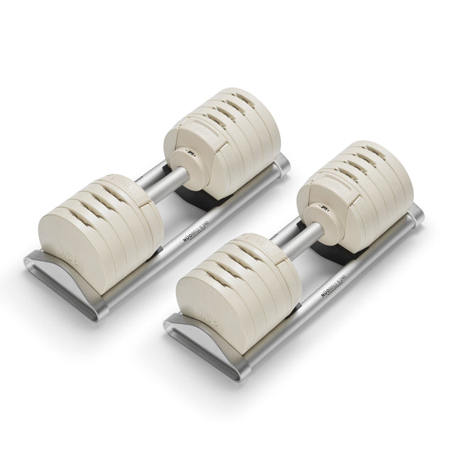 The NÜOBELL-S Adjustable Dumbbells by Bells of Steel feature stacked, white rectangular weight plates on metal trays and a modern, minimalist design—making them the perfect addition to any home gym.