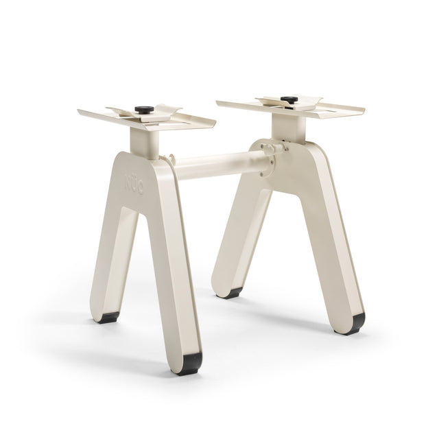 The NÜOBELL-S Floor Stand by Bells of Steel features a modern off-white metal base with two angled legs and a horizontal support, echoing the sleek design of Adjustable Dumbbells; shown here on a white background.