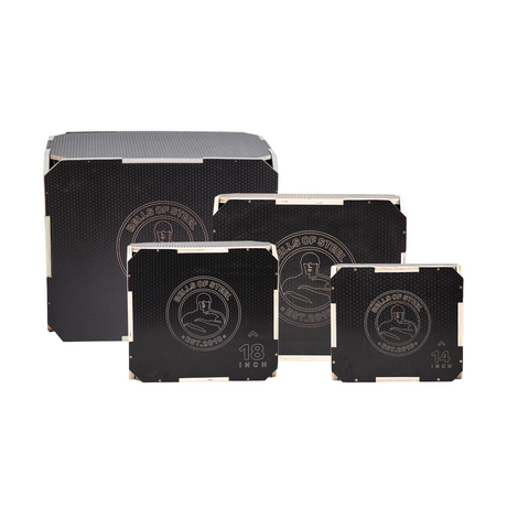 Three black square plyometric jump boxes labeled 12, 14, and 18 inches stand in front of a black storage box. Each box features a circular design with a person squatting and text on the front.