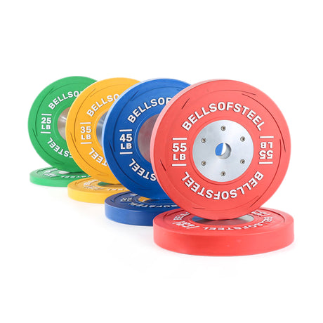 A set of colorful weight plates—green, yellow, blue, and red—labeled with their weights and “Bells of Steel,” stacked in a row on a white background.