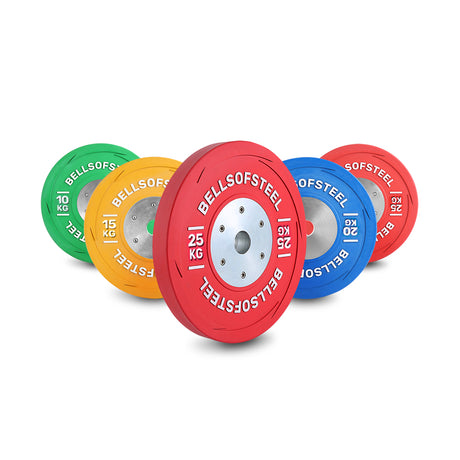 Four colorful weight plates—green (10 kg), yellow (15 kg), red (25 kg), and blue (20 kg)—with "Bells of Steel" branding are displayed upright on a white background.