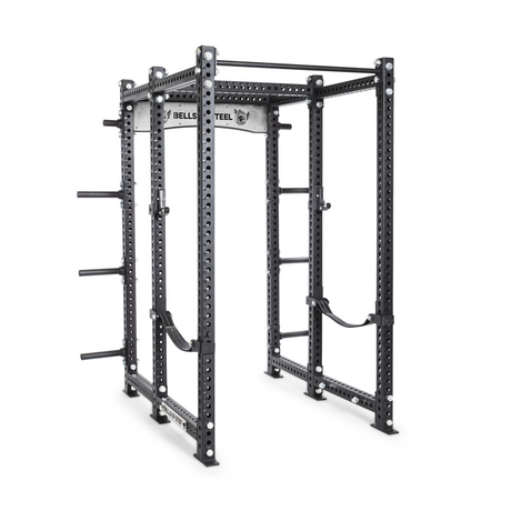 A black steel power rack with multiple holes for attachments, pull-up bars, safety arms, and weight plate holders, set against a white background.