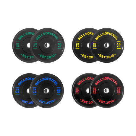 The Dead Bounce Conflict Bumper Plate Sets by Bells of Steel include four pairs of black plates (10 kg green, 15 kg yellow, 20 kg blue, 25 kg red) labeled with “BELLS OF STEEL EST. 2010” and made from virgin rubber for a dead bounce.