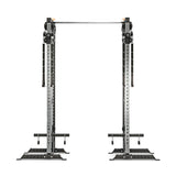 The Bells of Steel Cable Tower Squat Stands is a black and silver gym machine featuring adjustable pulleys, a sturdy metal frame, and an integrated pull-up bar, shown from the front against a white background.