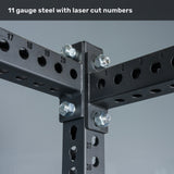 Close-up of the Bells of Steel Manticore Four Post Power Rack Builder’s black 3" x 3" steel uprights, featuring laser-cut 1" numbered holes and heavy-duty bolts at each intersection—ideal for any home gym setup. Text at the top reads, "11 gauge steel with laser cut numbers." The robust construction ensures this power rack is both reliable and durable.