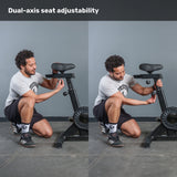 A man adjusts the seat height and angle on the Bells of Steel Residential Air Bike with Wind Guard, showcasing its dual-axis seat adjustability—an ideal feature for any home gym.