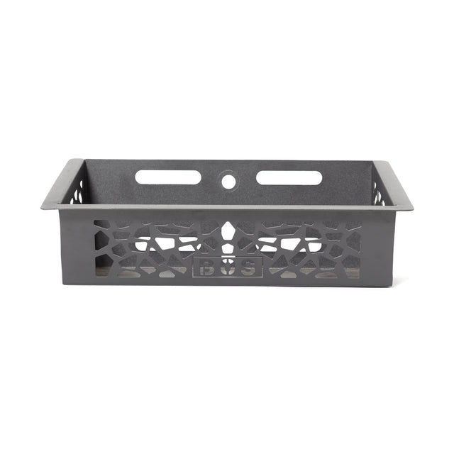 The Bells of Steel Rack Attached Storage Basket is a black rectangular metal basket with patterned cut-out sides, two horizontal slots, and a circular hole at the back—perfect for organizing gym or fitness accessories.