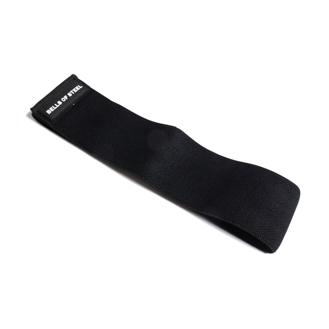 The Bells of Steel Glute Loop is a black non-slip resistance band featuring the brand’s white text on one end, laid flat on a white background—ideal for intense glute workouts.