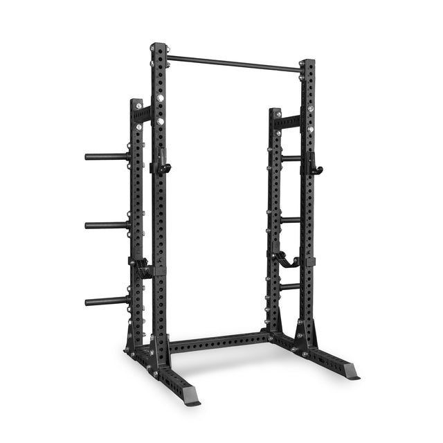 The Bells of Steel Manticore Half Rack Builder is a black metal power rack featuring robust 3" x 3" uprights with 1" holes, adjustable supports, a pull-up bar, and weight plate storage pegs—perfectly designed for strength training and weightlifting in your home gym.