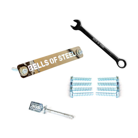 A set of Hydra Hardware by Bells of Steel on a white background, featuring concrete anchor bolts, a metal "BELLS OF STEEL" nameplate, a black wrench, various screws, and a BOS-branded hex key.