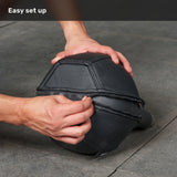 A person zips up a black, multi-paneled Bells of Steel Kettlebell Wrap on a gray floor, providing extra floor protection. The text “Easy set up” appears at the top left on a dark overlay.