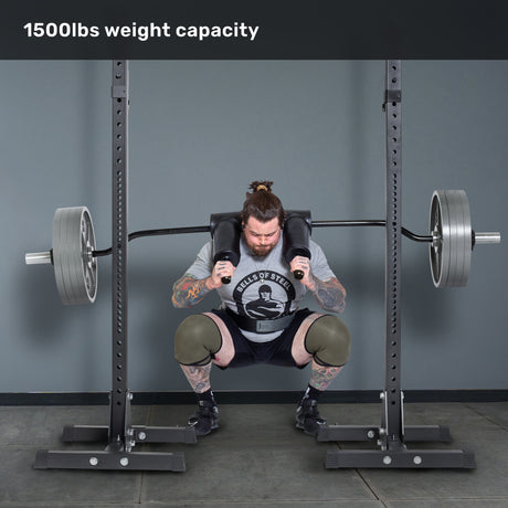 A man with tattoos and knee sleeves squats a loaded Bells of Steel Safety Squat Bar - The SS4 on a rack. Text above says "1500lbs weight capacity." Perfect gear for your next leg day.
