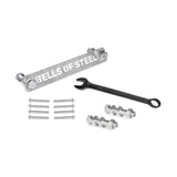 The Bells of Steel Manticore Hardware kit includes a labeled metal bar, black wrench, bolts, nuts, screws, and concrete anchor bolts—everything you need to assemble your Manticore Power Rack on a white surface.
