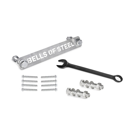 The Bells of Steel Manticore Hardware kit includes a labeled metal bar, black wrench, bolts, nuts, screws, and concrete anchor bolts—everything you need to assemble your Manticore Power Rack on a white surface.