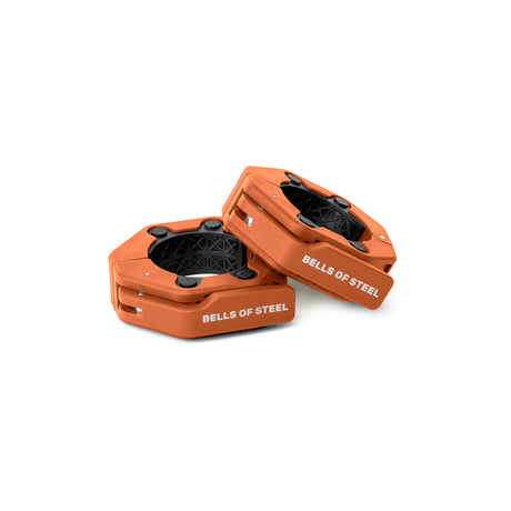 Two orange, hexagonal Magnetic Clamp Collars by Bells of Steel with black interiors are shown on a white background: one upright and one angled.