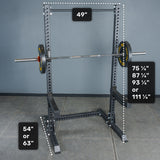 The Bells of Steel Manticore Squat Stand Builder features sturdy 3" x 3" uprights with 1" holes, a sleek black finish, and clearly labeled measurements: 49" width, base depths of either 54" or 63", and multiple height options—75¼", 87¼", 93¼", or a towering 111¼". This highly versatile squat stand is the perfect addition to any home gym and pairs seamlessly with your favorite barbell.