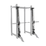 The Bells of Steel Smith Machine Rack Attachment, shown in silver with a barbell, is designed for weightlifting and strength training. The equipment is displayed against a plain white background.