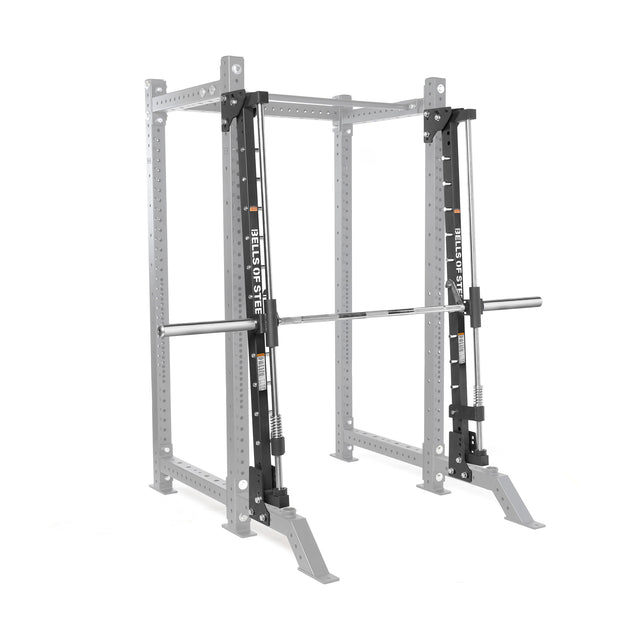 The Bells of Steel Smith Machine Rack Attachment, shown in silver with a barbell, is designed for weightlifting and strength training. The equipment is displayed against a plain white background.