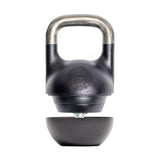The Bells of Steel 6-12KG Adjustable Kettlebell, inspired by Mark Wildman, features a black competition-style design with a partially detached bottom revealing its adjustable mechanism, shown on a white background.